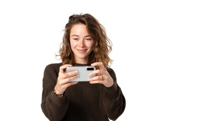 Fototapeta premium Young woman smiling while holding a smartphone, white isolate background.