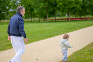 Senior Man Walking With Toddler