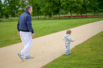 Grandfather Walking Beside Curious Child