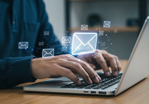 Person typing on laptop with glowing email icons