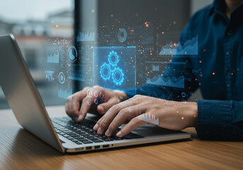 Hands typing on a laptop displaying digital charts and data analytics