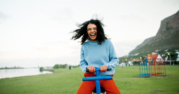 Face, laughing and seesaw with woman outdoor at lake in park for comedy, excitement or morning fun. Field, pov and space with funny person at playground in nature for holiday, vacation or wellness