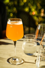 A close-up of a glass of beer illuminated by the sun. Restaurant table set outdoors. Beautiful...