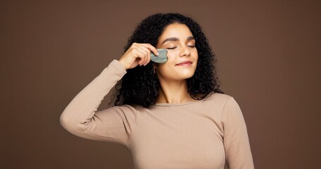 Beauty, skincare and woman with gua sha in studio for facial care, detox and lymphatic drainage....
