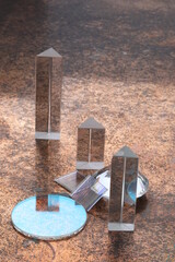 Group of four glass pyramid shaped objects are on a brown surface