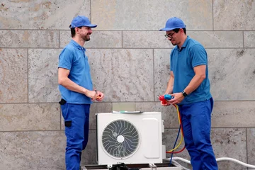 Fotobehang Hispanic HVAC Technician Repairs Heat Pump © Andrey Popov