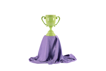 a green trophy sitting on top of a purple cloth