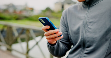 Exercise, break and hands with phone on bridge for fitness app, check stats or workout performance. Runner, person and smartphone in nature for cardio progress, track running speed and training timer