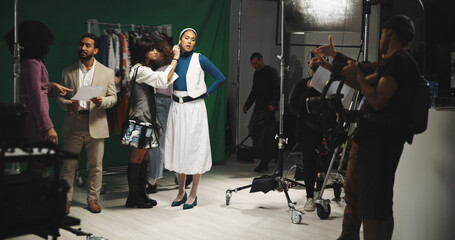 Actress, woman and makeup artist in production studio for preparation with green screen. Behind the scenes, stylist and cosmetics for beauty with celebrity director for movie set, film or videography