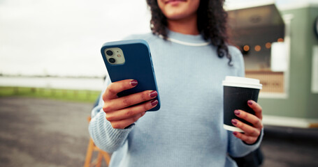 Woman, hands and phone with coffee for review, post or social media at outdoor barista stand....