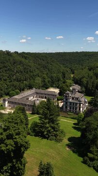 Aerial view of Altenberg Cathedral in lush green hills of Odenthal, Germany under a clear sky