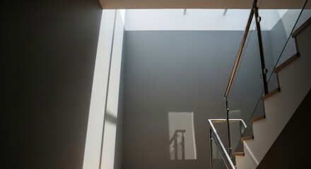 Modern Staircase with Glass Railing and Dramatic Light and Shadow Play