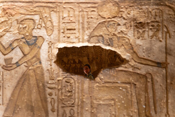 Tourist observing ancient egyptian hieroglyphs at luxor temple
