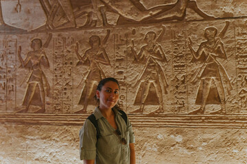 Tourist admiring ancient egyptian bas reliefs inside a temple