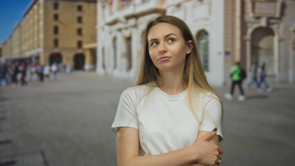 Fototapeta premium Woman standing outdoors on a busy city street in casual attire with an expression of confidence and curiosity surrounded by urban life and architecture capturing everyday moments.