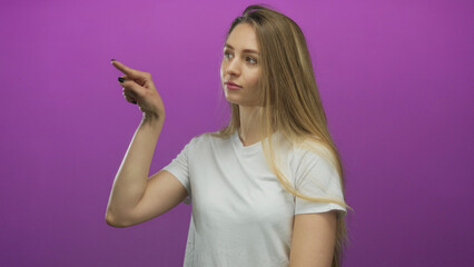 Young woman pointing with confident expression over isolated purple background wearing white shirt.