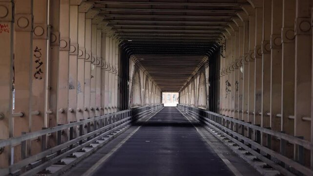 Road passing under Tyne Bridge in Newcastle upon Tyne, UK, featuring graffiti and metal structures