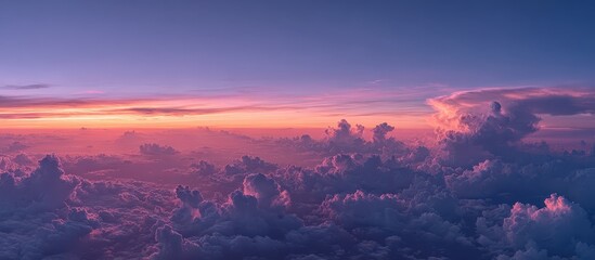 Aerial view of a breathtaking sunset over a sea of purple and pink clouds