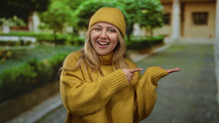 Woman in yellow sweater smiles outdoors at park surrounded by greenery exhibiting joyful emotion...