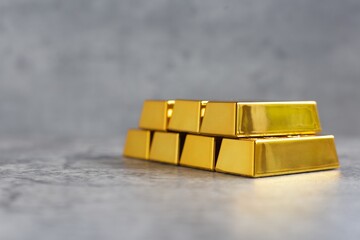 Gold bars pile on modern cement background