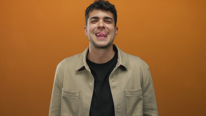 Man holds tongue by sticking it out in a studio shoot featuring a young hispanic male subject...