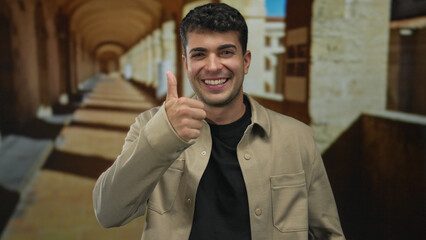 Fototapeta premium Man pointing finger to mouth in stone corridor; happiness excitement.