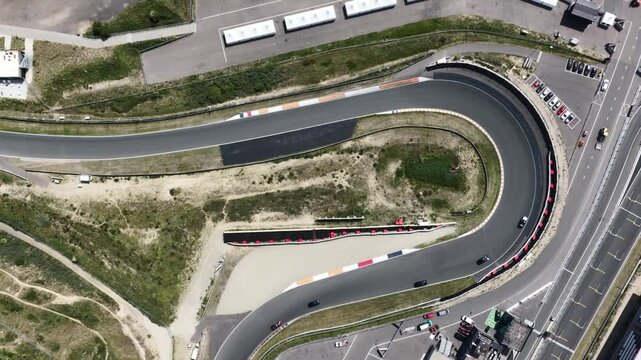 Aerial view of a sharp turn at Zandvoort race track in Netherlands with cars navigating the curve