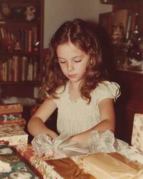 vintage photo of girl opening birthday gifts, 1980s film	