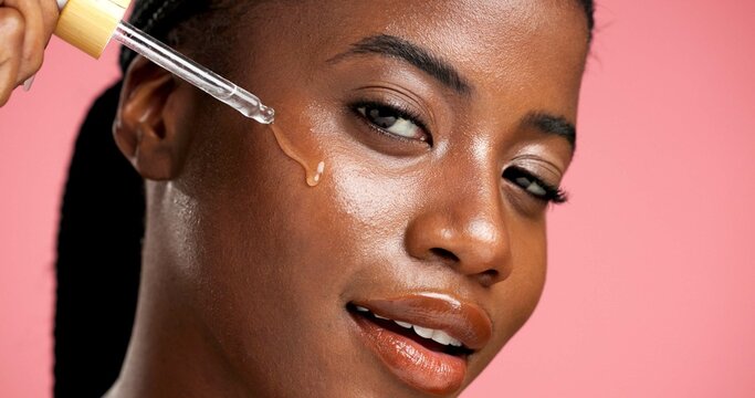 Portrait, beauty and black woman with serum, skincare and facial treatment for healthy skin or glow. Studio background, oil and person with cosmetics for shine, anti aging and wellness for face