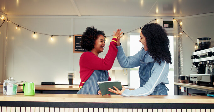 Tablet, high five and women in food truck outdoor for online orders, customer review and celebrate. Restaurant, mobile cafe and happy waitress team on digital tech for bistro ratings, sale or success - Powered by Adobe