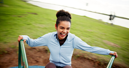 Woman, happy and spinning on roundabout at playground for workout break, adrenaline or energy....