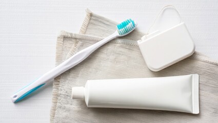 Dental care essentials: toothbrush, toothpaste, dental floss on fabric surface. Mockup for design. Concept.
