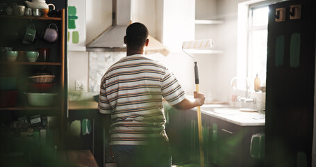 DIY, paint roller and thinking with black man in kitchen of new house for maintenance from back....