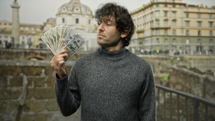 Man holding american dollars on a city street portrays financial success and urban lifestyle,...