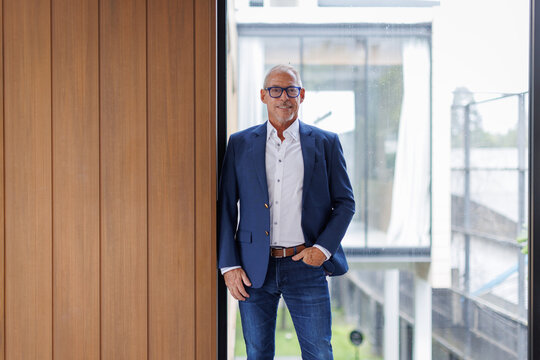 Portrait of Happy mature older male entrepreneur standing with smiling confident at camera.middle age male ceo leader business man standing in office.  - Powered by Adobe