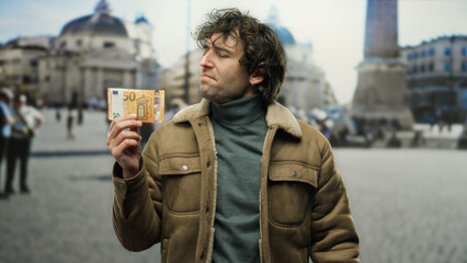Man holding euro banknote outdoors in vatican san pedro square with blurred architectural...