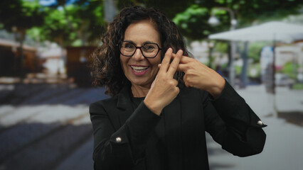Hispanic woman making hashtag gesture with fingers on a busy street; social media trend connection.