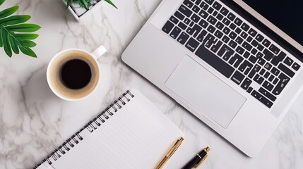 Laptop, coffee, notepad, and pens on marble desk top-down view for work