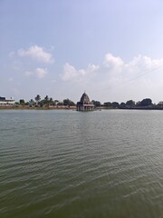 A spiritually resonant view of Thirukazhukundram, Tamil Nadu, India, capturing both the hilltop Vedagiriswarar Temple and the ancient foothill temple complex. The hill temple, dedicated to Lord Shiva,