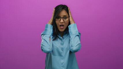 Young hispanic woman in stress holding her head in frustration against an isolated vibrant pink...
