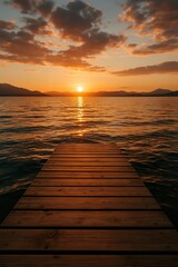 Obraz premium A beautiful and calming sunset over a lake, viewed from a wooden pier leading towards the horizon.