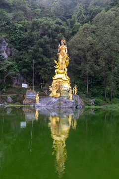 Dewi Danu statue at Danau Batur, Bali, Indonesia, a Hindu water goddess, is reflected in the water. It is a sacred site for offerings and ceremonies.