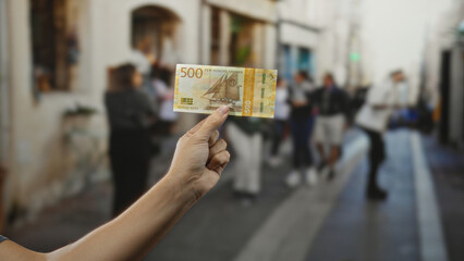 Man holding norwegian krone banknote on busy city street, showcasing vibrant urban scene with...