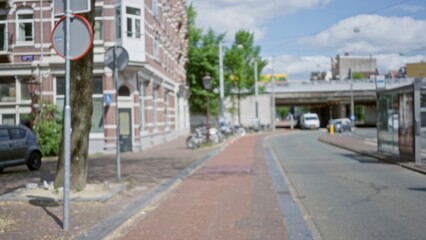Blurred view of a european city street featuring bicycles, cars, and brick buildings, under a clear sky, highlighting urban outdoor ambiance and architecture.