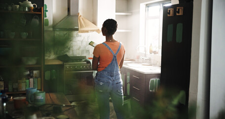 DIY, painting and thinking with black woman in kitchen of new house for maintenance from back....