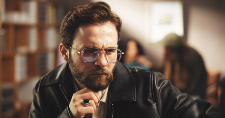 Thinking, man and director in studio for editing with post production, process or casting online. Planning, solution and filmmaker watching scenes for artistic project with shoot at creative agency.