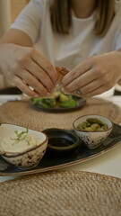 Woman enjoying mediterranean appetizers indoors at a restaurant showcasing rich food textures and casual dining atmosphere.