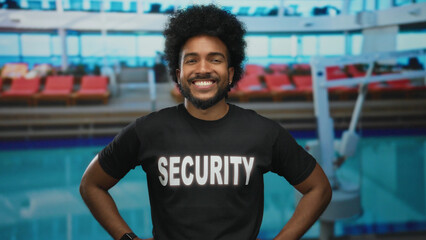 African american man in security uniform smiling on a cruise boat with the sea and seaside visible...