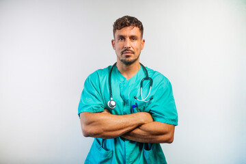 Confident male doctor in scrubs with arms crossed, looking at camera.
