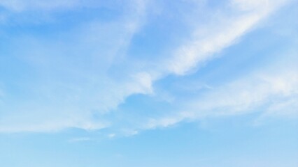 Beautiful scene of soft fluffy white clouds floating in a clear blue sky on a bright summer day, creating a calm and serene atmosphere. Ideal for nature, travel, relaxation, weather themed designs.